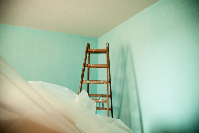 A ladder leaning against a blue wall in a room, providing a solution for hanging vinyls on the wall