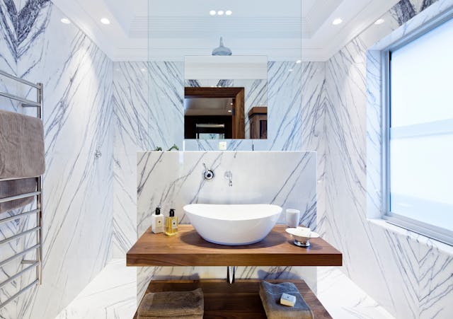 Luxurious bathroom with elegant marble walls and flooring, perfect for small spaces.